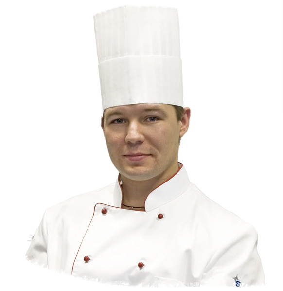 Koch in weiser Kochjacke mit roten Knöpfen. Auf dem Kopf trägt er eine Kochmütze
